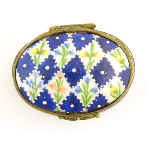 1206 - A 19thC Bilston / Battersea enamel pill box of oval form with a waisted body, the lid decorated with... 