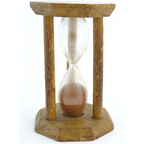 1210 - A 19thC Mauchline ware sand timer / hourglass, the octagonal top decorated with a vignette depicting... 