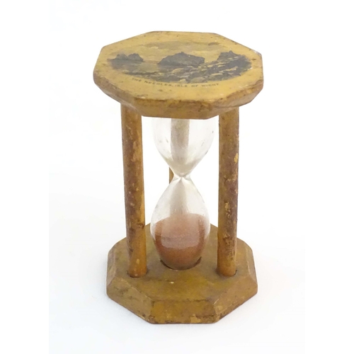 1210 - A 19thC Mauchline ware sand timer / hourglass, the octagonal top decorated with a vignette depicting... 