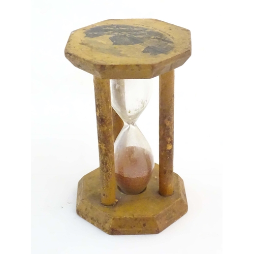 1210 - A 19thC Mauchline ware sand timer / hourglass, the octagonal top decorated with a vignette depicting... 