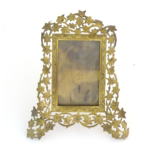 1235 - A Victorian brass easel back photograph frame, the surround with scrolling vine leaves. Approx. 7