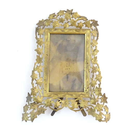 1235 - A Victorian brass easel back photograph frame, the surround with scrolling vine leaves. Approx. 7