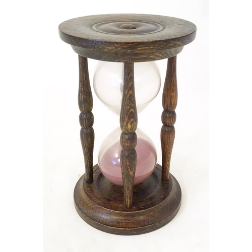 1255 - An early 20thC hourglass / sand timer with turned wooden ends supported by four turned treen columns... 