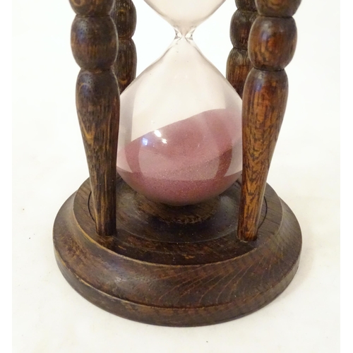 1255 - An early 20thC hourglass / sand timer with turned wooden ends supported by four turned treen columns... 