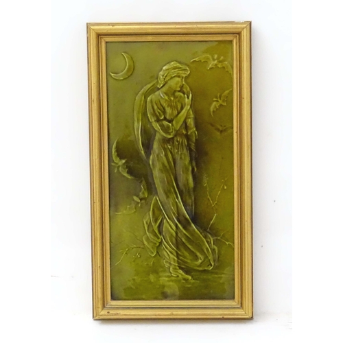 93A - A framed majolica tile with relief decoration depicting a lady in a night time landscape with bats a... 