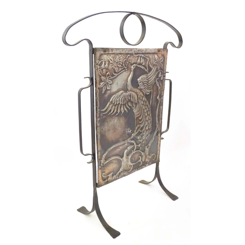 2092 - An Art Nouveau cast and wrought metal firescreen, the central section decorated with depiction peaco... 