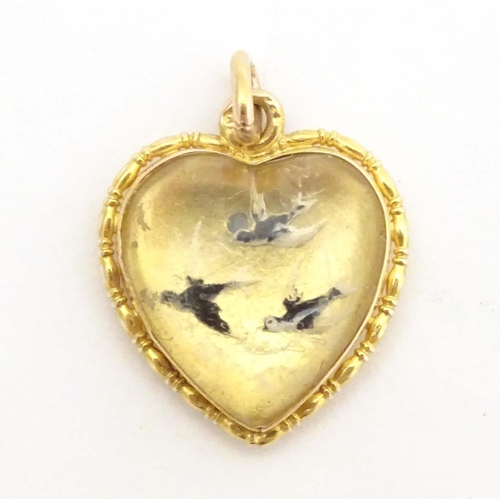 684 - A gold sweetheart pendant locket of heart form set with Essex crystal cabochon depicting three swall... 