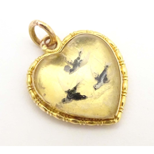 684 - A gold sweetheart pendant locket of heart form set with Essex crystal cabochon depicting three swall... 