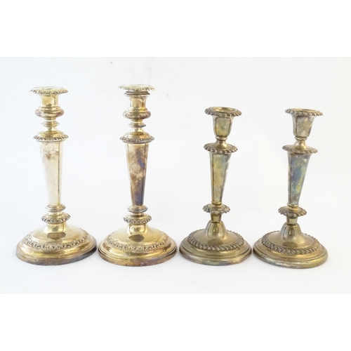 542 - A pair of silver plate candlesticks. Together with another pair of silver plate candlesticks. Larges... 