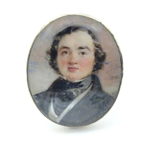 627 - A 19thC watercolour portrait miniature depicting a gentleman in a black jacket and cravat, within an... 