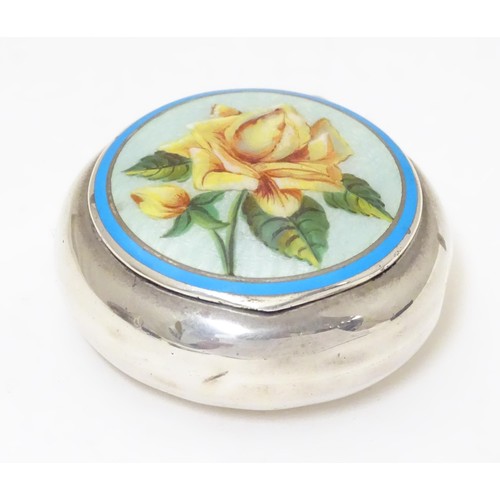 478 - A silver pill box of circular form with enamel floral detail to lid. Marked with importers mark for ... 