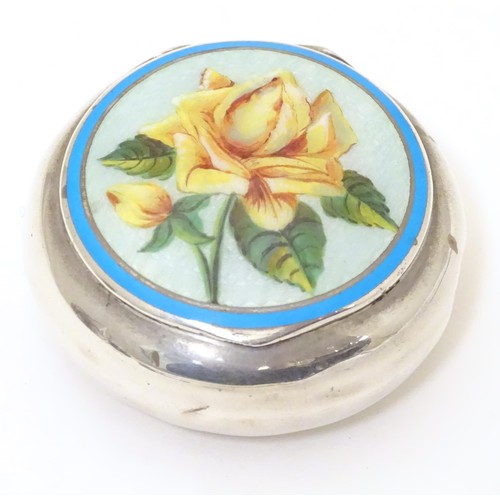 478 - A silver pill box of circular form with enamel floral detail to lid. Marked with importers mark for ... 