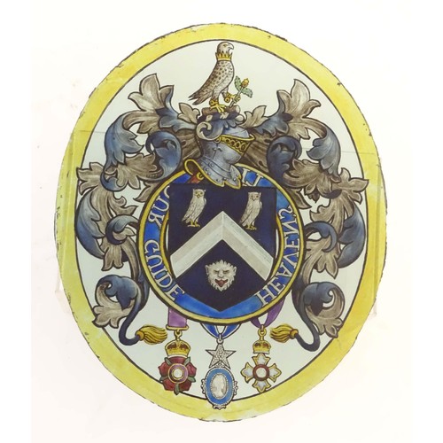 1257 - An early 20thC painted stained glass oval panel depicting a heraldic coat of arms depicting a shield... 