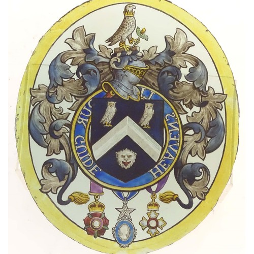 1257 - An early 20thC painted stained glass oval panel depicting a heraldic coat of arms depicting a shield... 