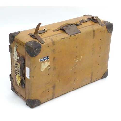 6 - An early to mid 20thC canvas and leather travelling trunk / suitcase, in tan finish with partial tra... 