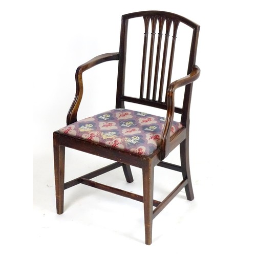 24 - An early 20thC mahogany carver chair with a shaped top rail above a fanned pierced back splat flanke... 