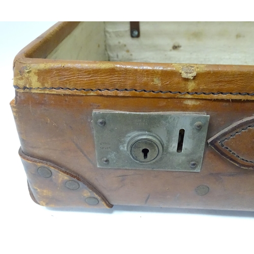 33 - A leather suitcase with reinforced corners and brass locks