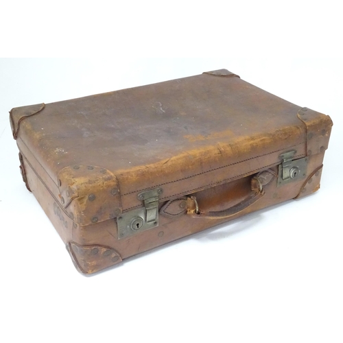 33 - A leather suitcase with reinforced corners and brass locks
