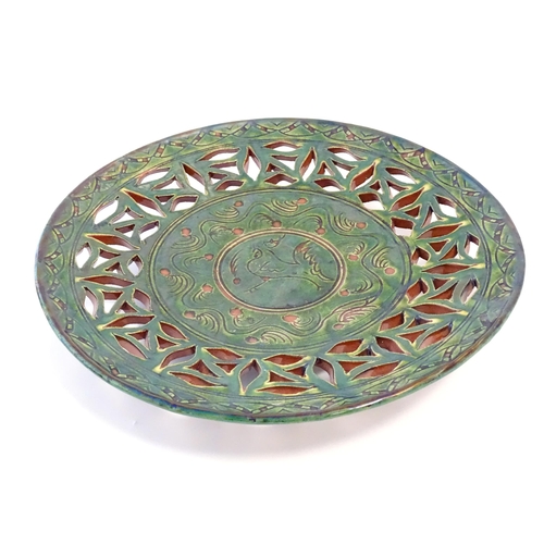 71 - A Spanish terracotta Gongora Ubeda charger with a green glaze, pierced decoration and stylised cocke... 