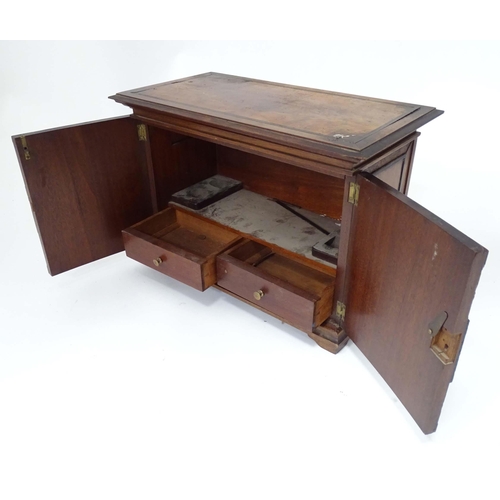 90 - A 20thC mahogany smokers table cabinet, the interior with pipe rests and two drawers. Approx 17