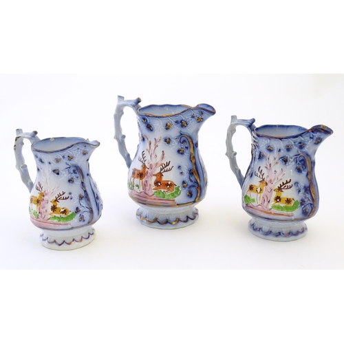 95 - A set of three Victorian graduated jugs with stag / deer decoration and Sunderland lustre and Flo bl... 