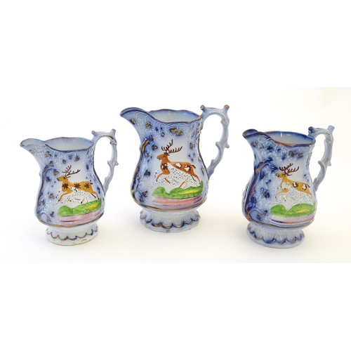 95 - A set of three Victorian graduated jugs with stag / deer decoration and Sunderland lustre and Flo bl... 