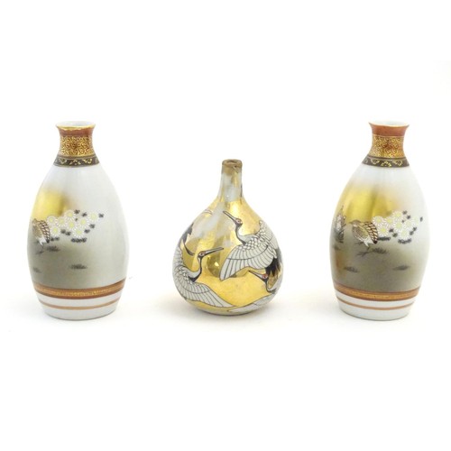 38 - Three Japanese vases, comprising a pair decorated with a landscape scene with quail birds and flower... 
