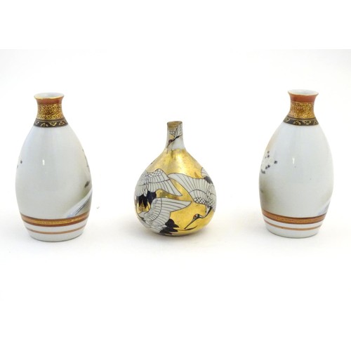 38 - Three Japanese vases, comprising a pair decorated with a landscape scene with quail birds and flower... 