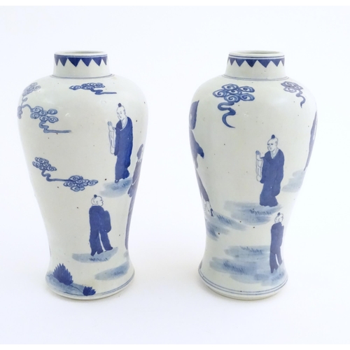39 - A pair of Chinese blue and white vases decorated with a Chinese dragon parade with figures in a land... 