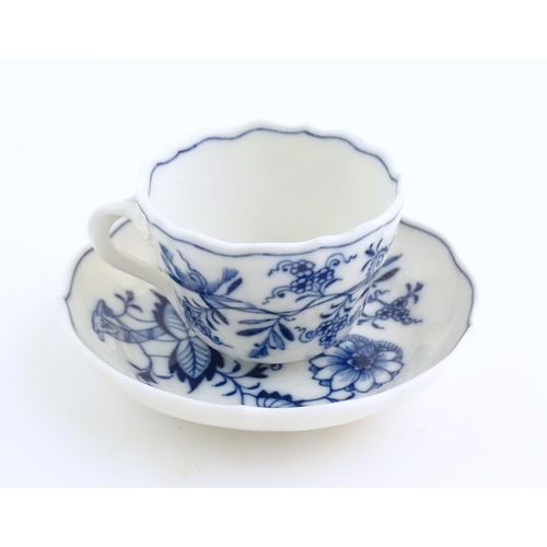 62 - A Meissen blue and white cup and saucer in the onion pattern. With blue crossed sword mark under. Cu... 