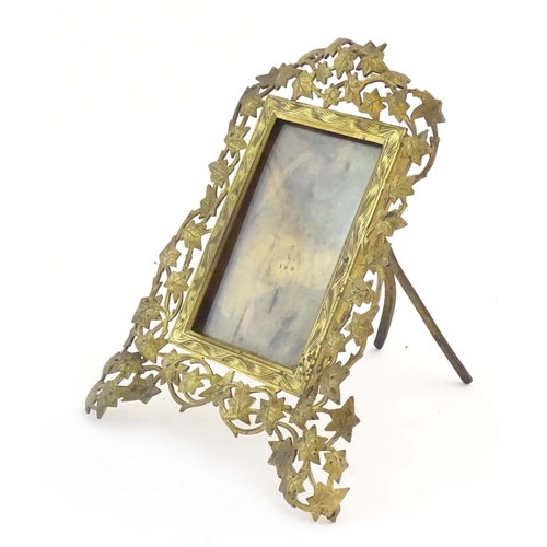 825 - A Victorian brass easel back photograph frame, the surround with scrolling vine leaves. Approx. 7