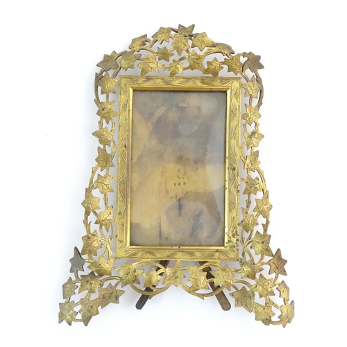 825 - A Victorian brass easel back photograph frame, the surround with scrolling vine leaves. Approx. 7