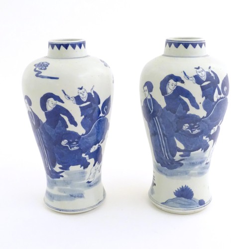 39 - A pair of Chinese blue and white vases decorated with a Chinese dragon parade with figures in a land... 