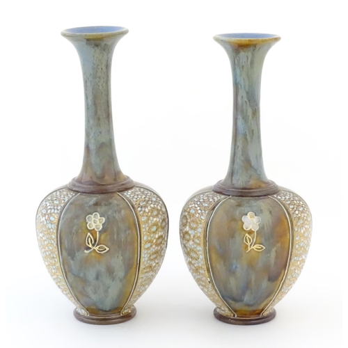 85 - Two Royal Doulton bottle vases with flared rims and floral decoration. Marked under, with maker's ma... 