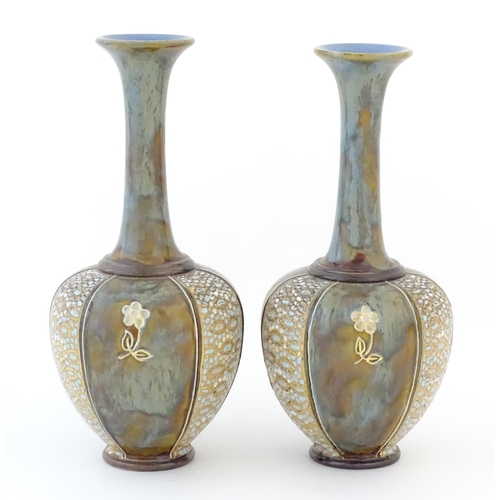 85 - Two Royal Doulton bottle vases with flared rims and floral decoration. Marked under, with maker's ma... 