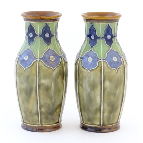 86 - A pair of Royal Doulton vases decorated with stylised floral detail and tube lining. Marked under, w... 