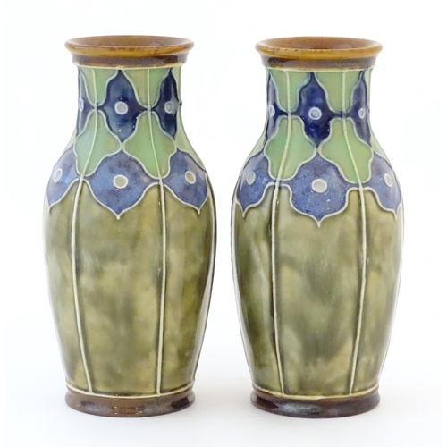 86 - A pair of Royal Doulton vases decorated with stylised floral detail and tube lining. Marked under, w... 