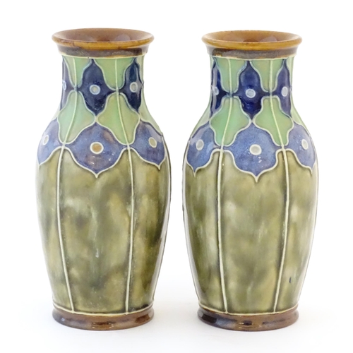 86 - A pair of Royal Doulton vases decorated with stylised floral detail and tube lining. Marked under, w... 