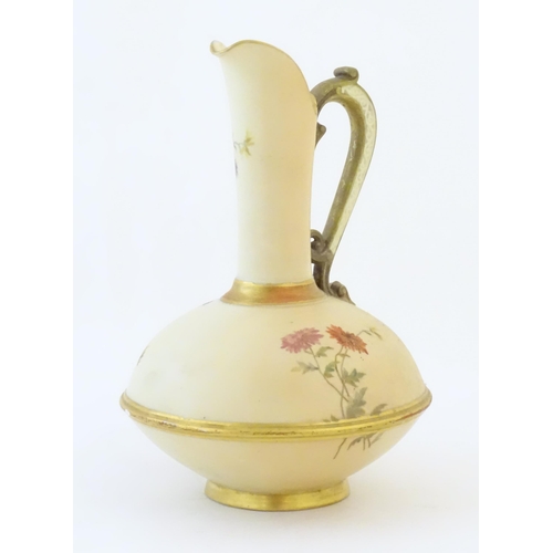 90 - A Royal Worcester jug / ewer with a cream ground, floral decoration and gilt highlights. Marked unde... 