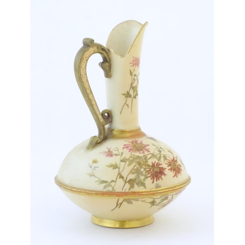 90 - A Royal Worcester jug / ewer with a cream ground, floral decoration and gilt highlights. Marked unde... 