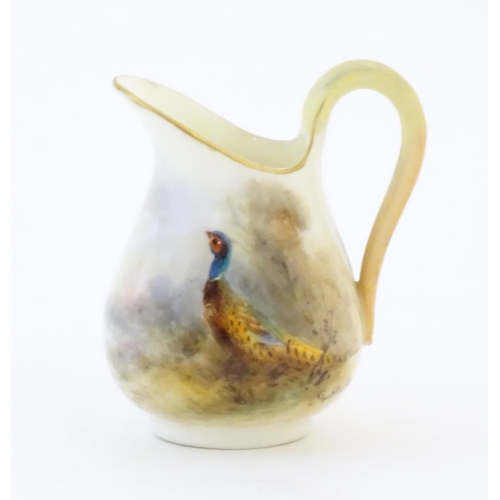 93 - A small Royal Worcester jug with hand painted decoration depicting a pheasant, signed Jas Stinton. M... 