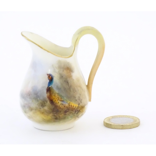 93 - A small Royal Worcester jug with hand painted decoration depicting a pheasant, signed Jas Stinton. M... 