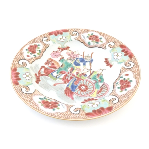 19 - A Chinese famille rose plate decorated with figures and a horse and cart, bordered by flowers and fo... 