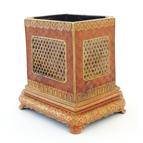 21 - A Chinese brush pot of squared form with a burnt orange ground, reticulated / pierced panels and gil... 