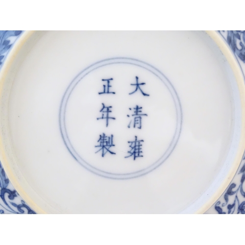 30 - A Chinese blue and white plate decorated with scrolling floral and foliate detail. Character marks u... 