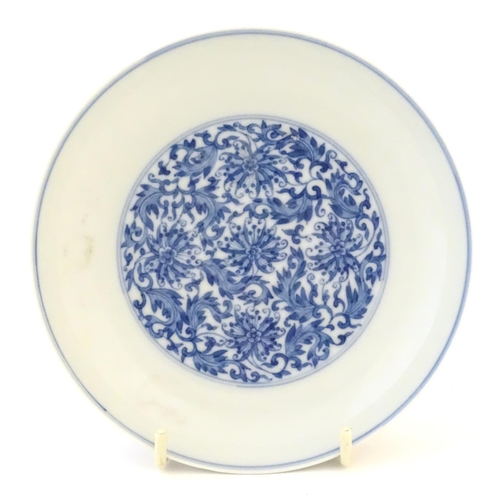30 - A Chinese blue and white plate decorated with scrolling floral and foliate detail. Character marks u... 