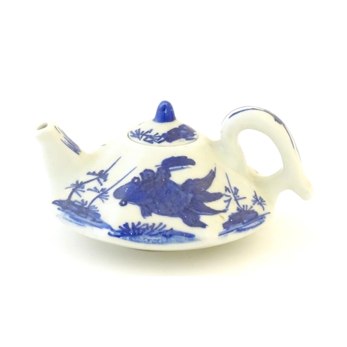 35 - A small Chinese blue and white teapot of octagonal form decorated with koi / carp fish. Character ma... 