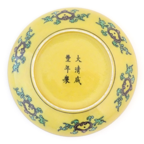4 - A small Chinese plate with a yellow ground with dragon and phoenix bird decoration. Character marks ... 