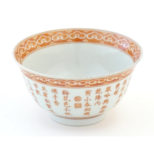 5 - A small Chinese red and white bowl decorated with flowers and foliage, the exterior with character s... 