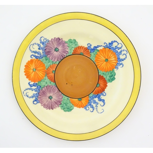 65 - A Clarice Cliff plate decorated in the Gayday pattern with flowers, foliage and a banded border. Mar... 